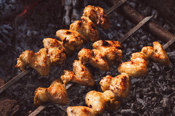 Chicken wings are grilling over charcoal. Outdoor BBQ concept