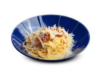 Creamy spaghetti carbonara topped with crispy bacon and freshly grated parmesan cheese on a deep blue plate.