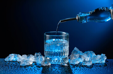 Vodka pours from bottle to glass.
