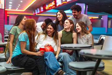 Group of friends laughing together while bowling