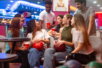 Friends enjoying bowling and drinks at alley