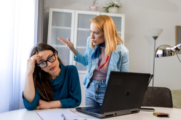Woman yelling at a colleague in an office, showing workplace bullying.