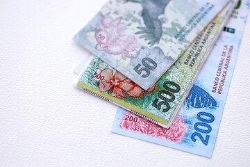 Argentine pesos money bills in big amount lies on white table close up