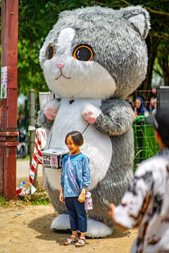 Putrajaya, Malaysia - September 19, 2024 Giant cat mascott with a child on the street.