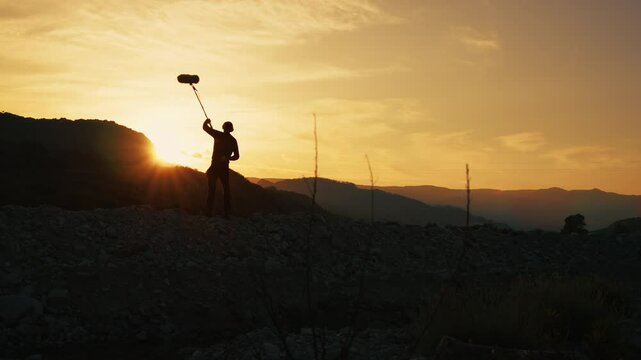Silhouette Of Film Sound Recordist Is Capturing Background Nature On The Mountains