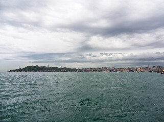View of Istanbul's historic peninsula and skyline from the Bosphorus Strait under cloudy skies