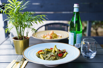 Penne pasta with pesto sauce and cherry tomatoes