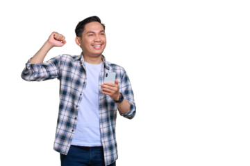Overjoyed young Asian man in plaid shirt celebrating success with a mobile phone, raising hands rejoiced big luck isolated on transparent background