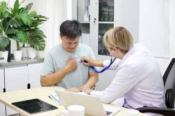 Obraz premium Doctor examines patient with chest pain using stethoscope in medical office