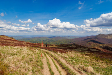 Scenic view of Bieszczady mountains with hiking trail in foreground and vibrant clouds above. Outdoor adventure in nature on a sunny day, perfect for exploration. © daily_creativity