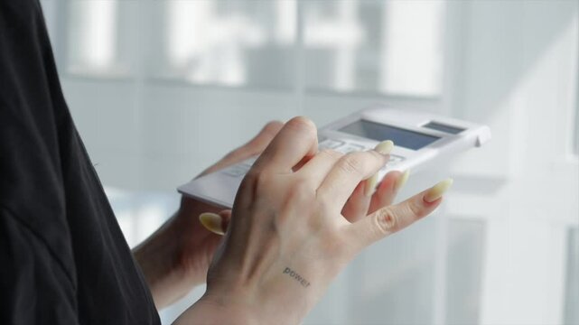 The seller calculates the profit on the calculator.
A girl with a calculator in her hands makes precise calculations.
The topic of economics and finance.
The financial industry and office work