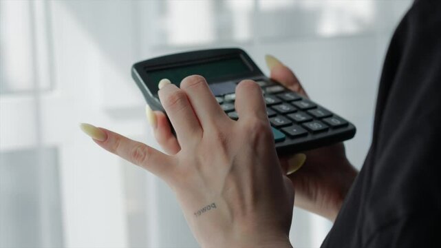 The seller calculates the profit on the calculator.
A girl with a calculator in her hands makes precise calculations.
The topic of economics and finance.
The financial industry and office work