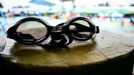 Black swimming goggles with water droplets
