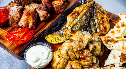 Delicious grilled meats and vegetables on a wooden platter