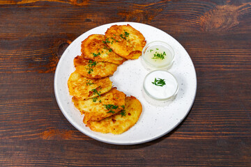 Delicious potato pancakes served with cream and herbs
