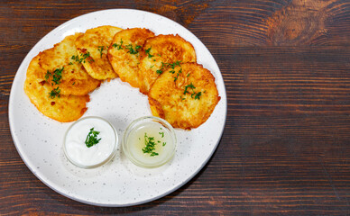 Delicious potato pancakes served with creamy dips on a rustic plate