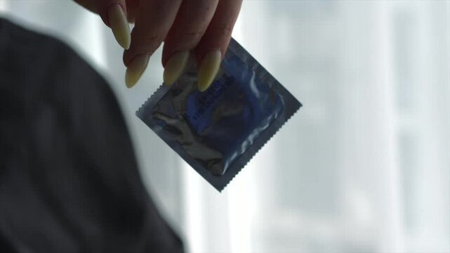 Condom in female hands close-up.
Girl unpacks condom.
Condom with lubricant.
Safe sex and sex education.
Condom, sex, orgasm, penis, hands