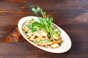 Fresh vegetable salad with creamy dressing on a wooden table
