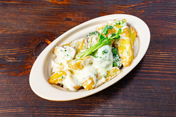 Creamy pasta dish with broccoli and potatoes served in a bowl