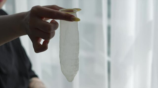 verticalCondom in female hands close-up.
Girl unpacks condom.
Condom with lubricant.
Safe sex and sex education.
Condom, sex, orgasm, penis, hands