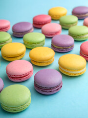 Obraz premium The background is black, with colorful macaroons. The small French pastries are placed on the sides of the image, leaving the center free - perhaps for an inscription. The image is designed as a templ