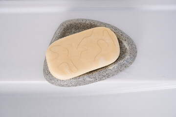 White soap in a soap dish with hair on the sink