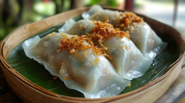 Steamed dumplings (Khanom Jeeb) on a bamboo tray, translucent wrappers, minced pork filling, topped with crispy garlic.