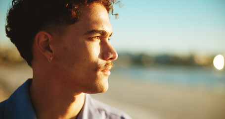 Sunset, thinking and ocean with man, vacation and nature with memory, reflection and decision Seaside, summer holiday and person with weekend break, wonder and choice with peace, beach or travelling