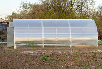 Small plastic greenhouse in the field