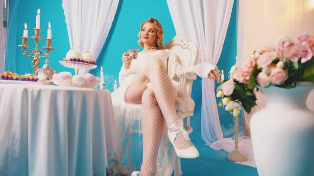 woman queen royal person sitting on chair at dinner table drinking hot tea dessert cakes pies marshmallows sweet confectionery. Fairy Girl princess having breakfast Victorian style room vintage dress