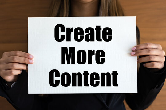Naklejki Create more content. Woman holds a white page, with black letters. Ideas, producing, creativity, content management system.