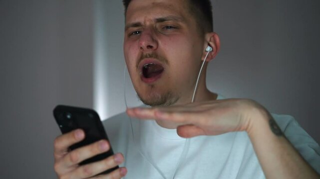 Vacuum headphones in the ears of a young guy dancing in the room to his favorite song.
A guy relaxes to songs and music.
Headphones in the ears.
Vacuum headphones.
Listening to music