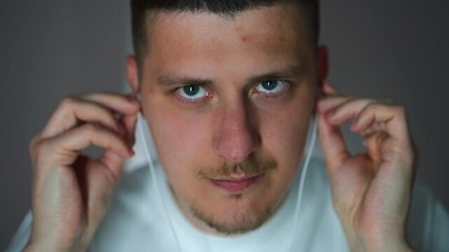 Vacuum headphones in the ears of a young guy dancing in the room to his favorite song.
A guy relaxes to songs and music.
Headphones in the ears.
Vacuum headphones.
Listening to music