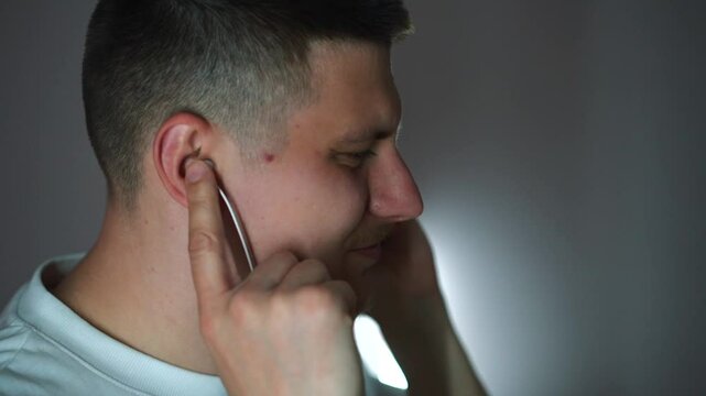 Vacuum headphones in the ears of a young guy dancing in the room to his favorite song.
A guy relaxes to songs and music.
Headphones in the ears.
Vacuum headphones.
Listening to music