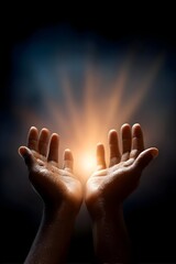 Hands reaching for a glowing light in darkness