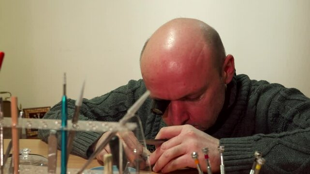 Dedicated clockmaker meticulously begins his craft