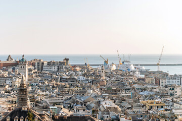 View of Genoa's rooftops at sunset, showcasing the city’s historic skyline and warm golden light.