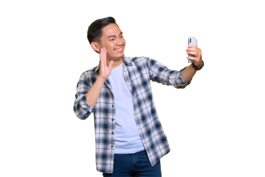 Cheerful young Asian man in plaid shirt doing selfie shot on mobile phone waving hand isolated on transparent background