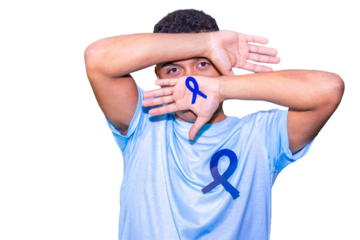 Young man covering his face with blue ribbon for colon cancer awareness month.