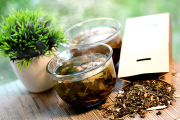 Two cups of herbal tea on natural summer background