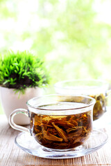 Two cups of herbal tea on natural summer background