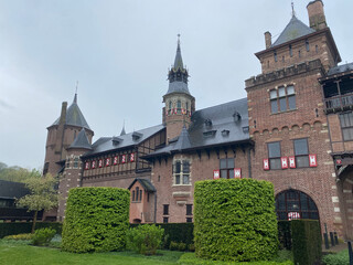 Exterior view of the majestic De Haar Kastel in the Netherlands, showcasing its impressive towers, moats, and red-brick architecture