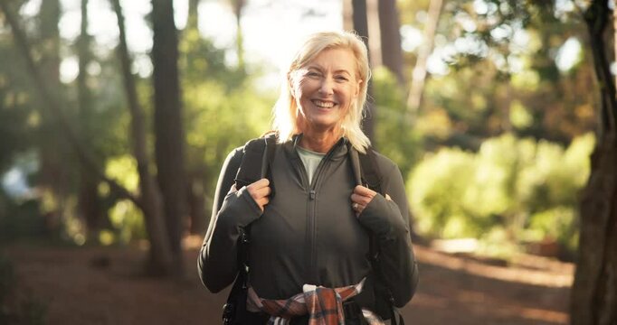 Hiking, mature woman and face in forest for adventure, retirement hobby and cardio wellness. Senior person, smile and portrait with backpack for trekking, explore and holiday sightseeing in woods