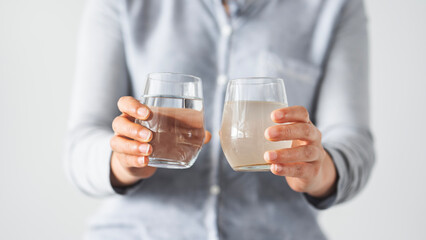 Woman holding clean and dirty water