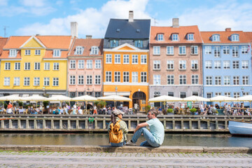 Colorful waterfront buildings and relaxed visitors in charming Copenhagen Denmark