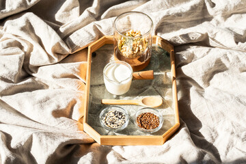 Breakfast in Bed with Tray Containing Yogurt, Granola, Sesame Seed and Flaxseed Bowls. Healthy...