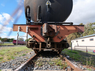 Rear view of an Old dilapidated oil tanker on rusted railroad track