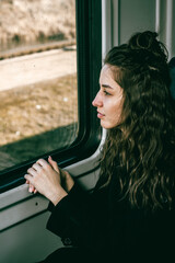 A girl on a train looks out the window