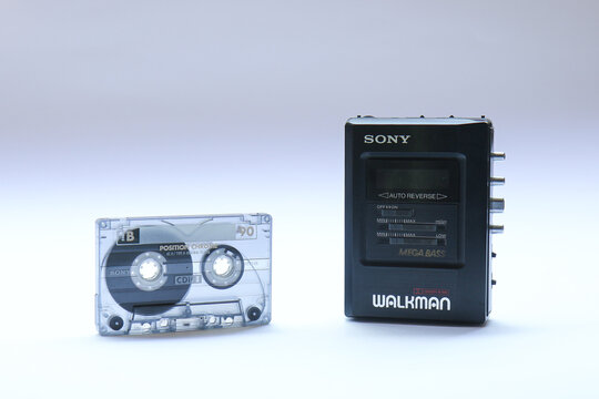 Berlin, Germany - May 3, 2025: Vintage Sony Walkman next to an audio cassette on white. The Sony WM-B47 was a popular portable cassette player in the 80s and 90s.