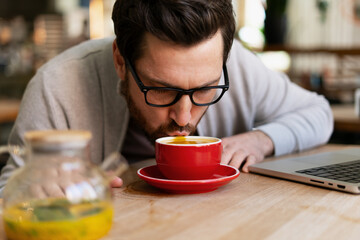 Businessman smelling and tasting coffee during a break in a cafe